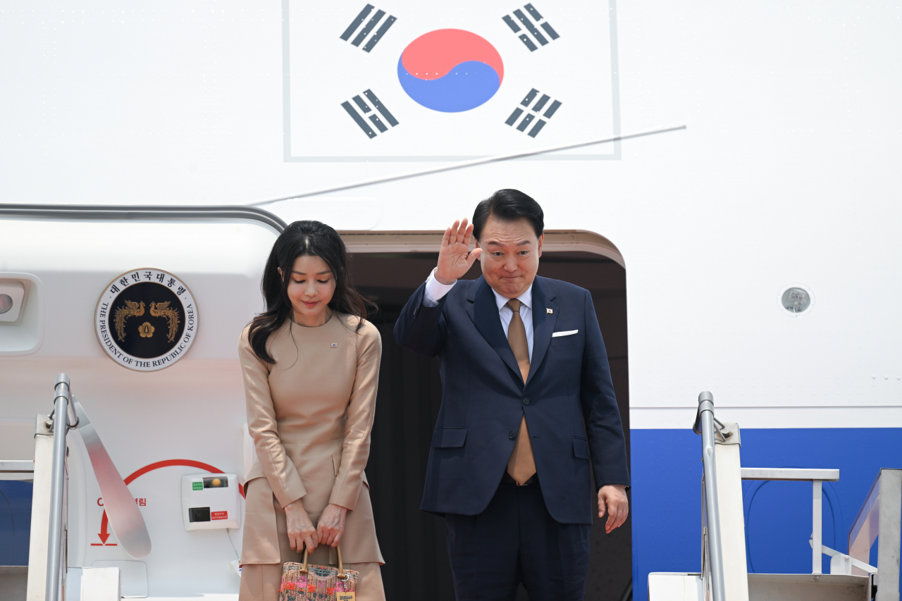 인도네시아 방문 일정을 마친 윤석열 대통령과 부인 김건희 여사가 8일(현지시간) 자카르타 수카르노 하타 국제공항에서 인도로 출발하기전 전용기인 공군 1호기에 올라 환송객들에게 인사하고 있다. [연합]