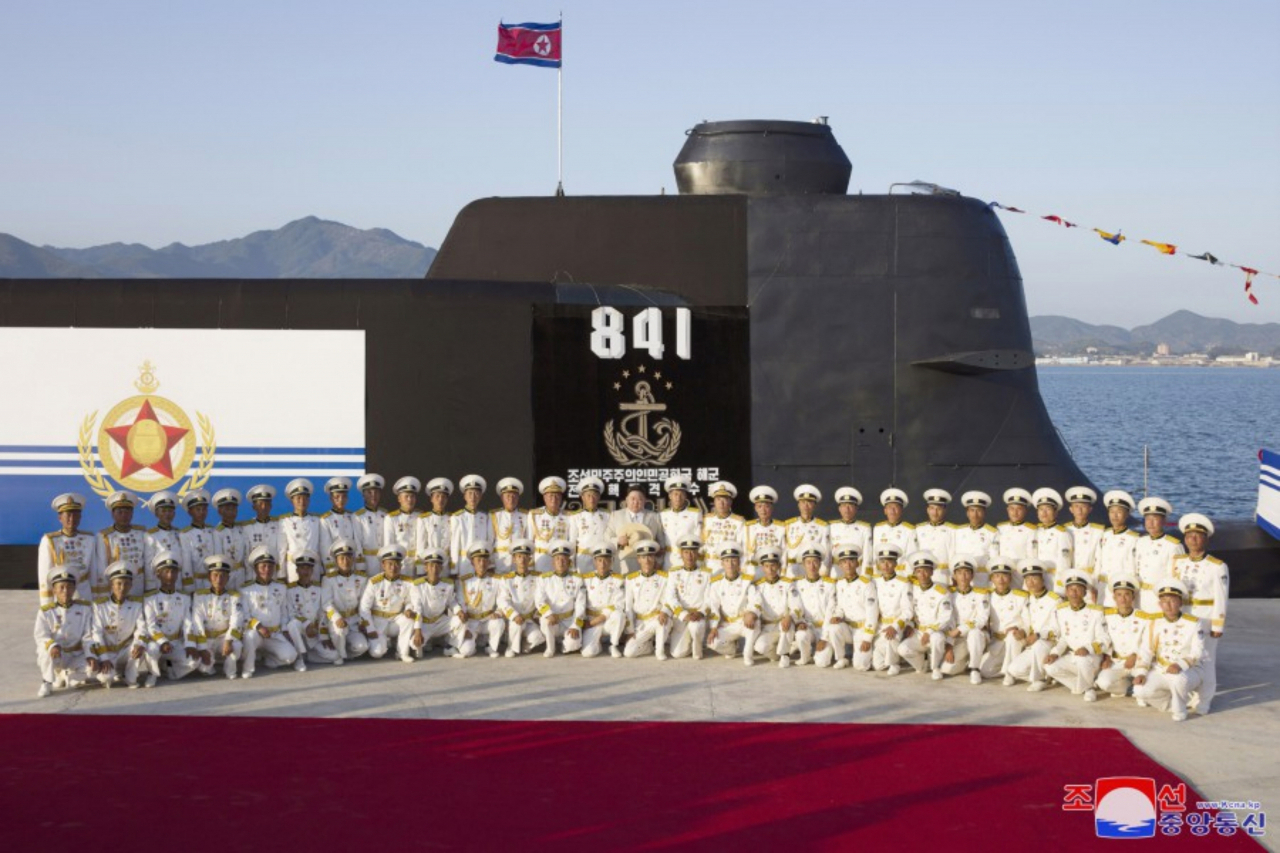 North Korean leader Kim Jong-un (second row, center) joins a group photo session with soldiers of the North's Navy during a ceremony on Wednesday, to launch a newly built "tactical nuclear attack submarine," in this photo taken from the website of North Korea's official Korean Central News Agency on Friday. (Yonhap)