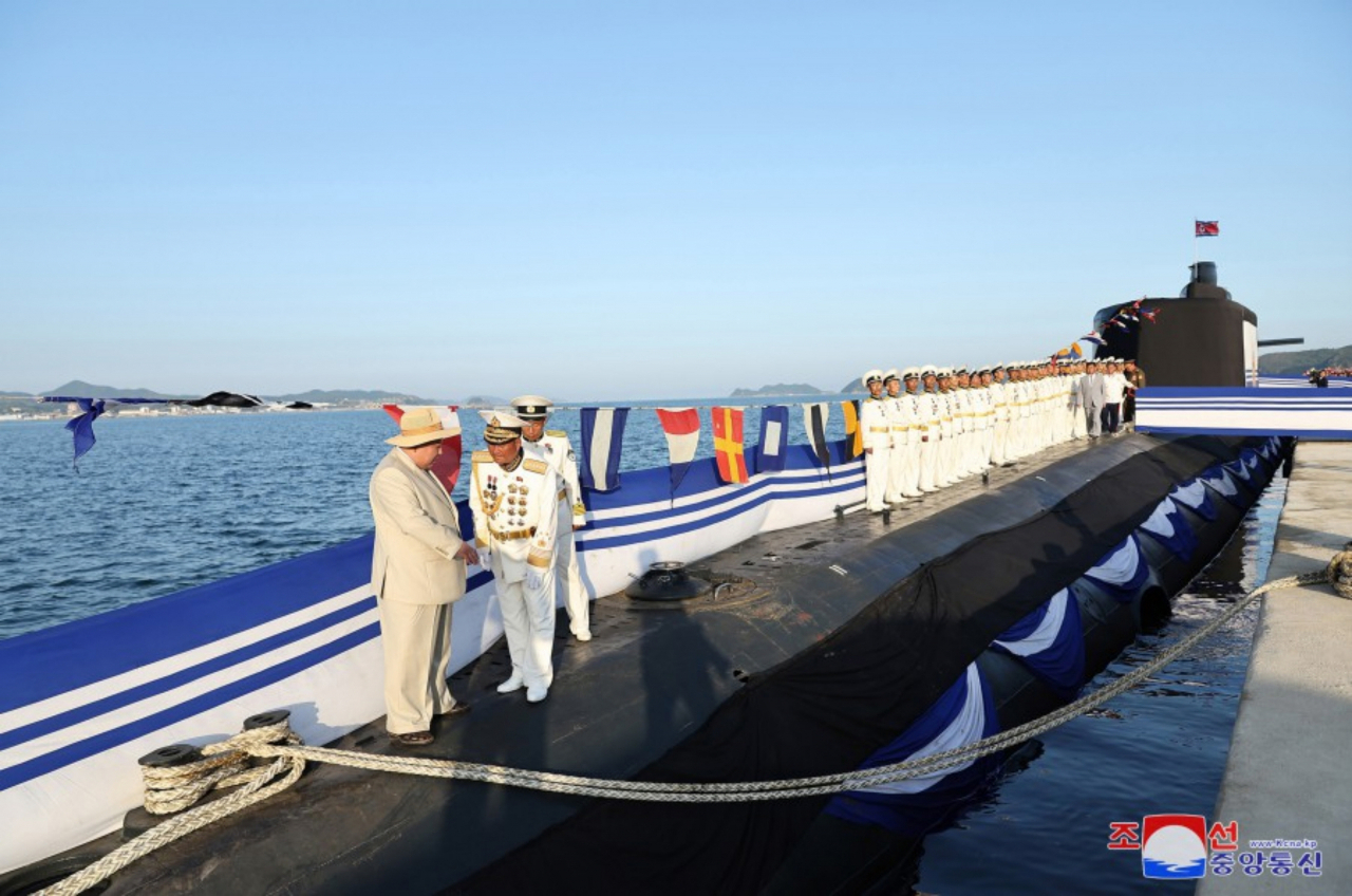 North Korean leader Kim Jong-un (far left) attends a ceremony on Wednesday to launch a newly built "tactical nuclear attack submarine," in this photo taken from the website of North Korea's official Korean Central News Agency on Friday. (Yonhap)
