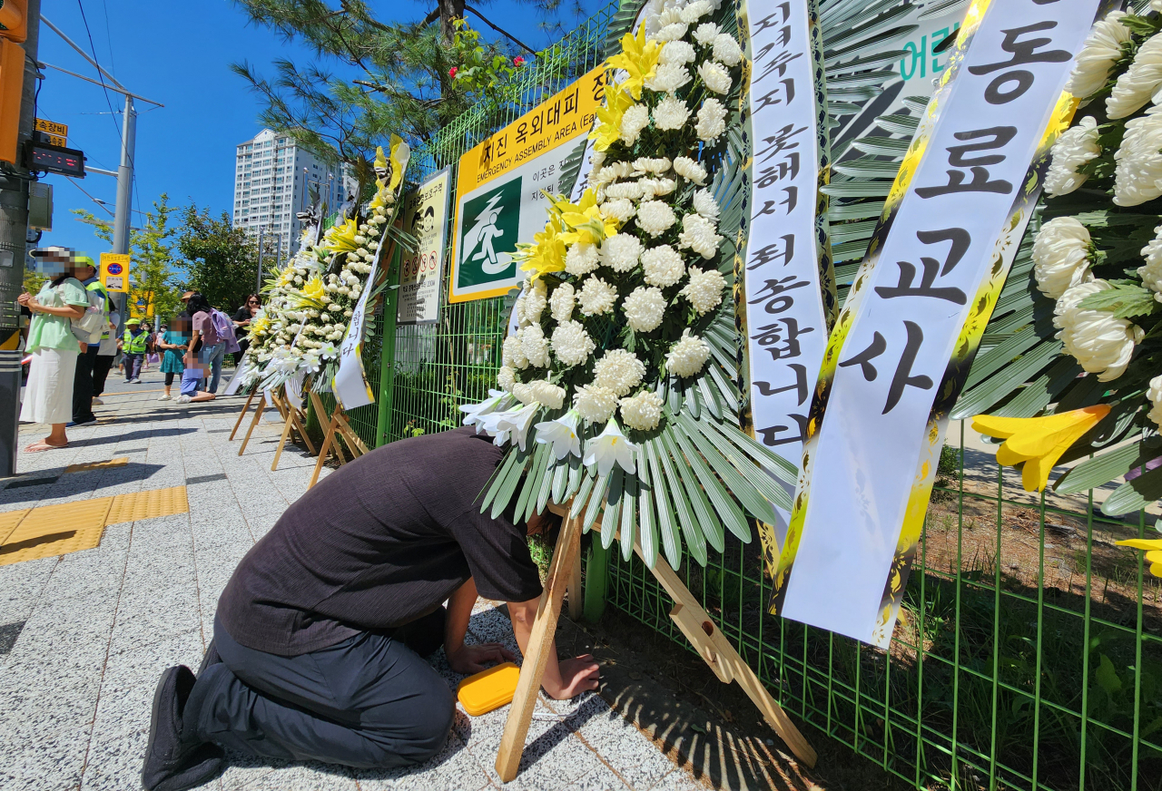 4년간 지속적인 악성 민원에 시달렸던 대전 유성구의 한 초등학교 교사가 극단적인 선택을 한 가운데, 한 동료 교사가 8일 오후 숨진 교사가 근무했던 학교 앞에 놓인 추모 화환 앞에서 오열하고 있다. 연합뉴스