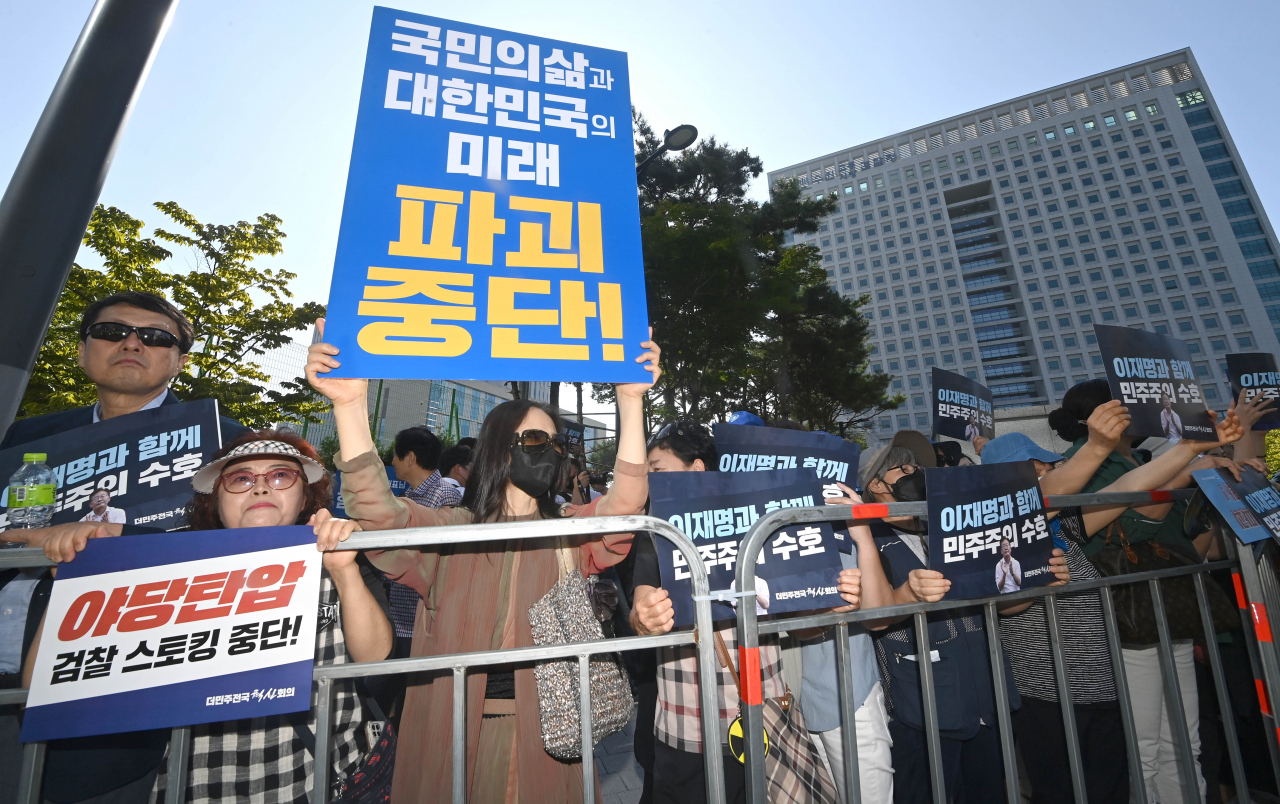 9일 이재명 더불어민주당 대표 지지자들이 이 대표가 쌍방울그룹 대북송금 의혹 관련 피의자 신분으로 조사를 받는 수원지방검찰청 앞에서 피켓을 들고 있다. [연합]