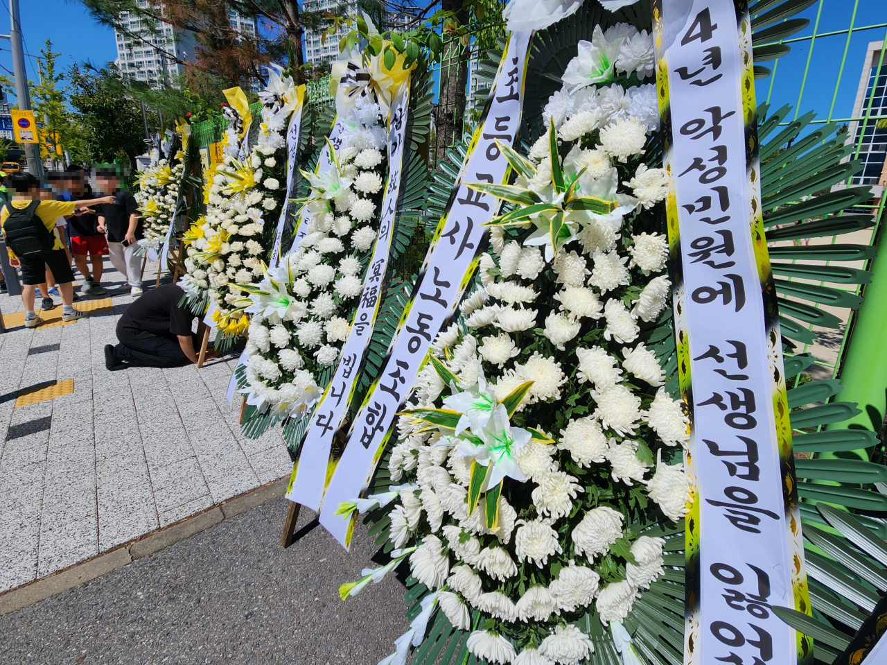 악성민원에 시달리다 지난 8일 극단적 선택을 한 대전 유성구의 한 초등학교 교사가 근무했던 학교 앞에 추모 화환이 놓여 있다.[연합]