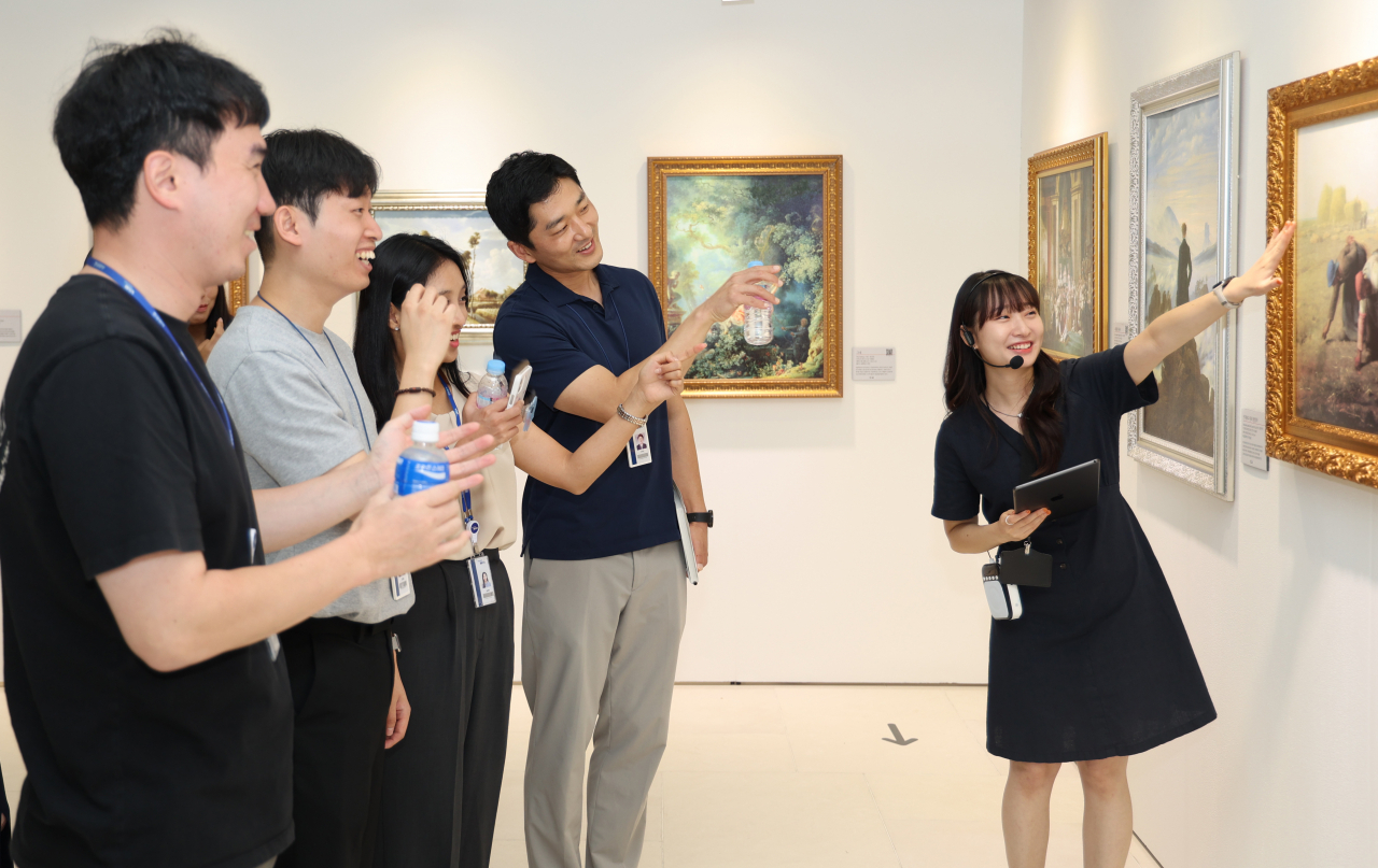 현대위아 임직원들이 11일 경상남도 창원시 현대위아 본사에서 열린 ‘현대위아 아트페어’에서 전문 해설가의 설명을 들으며 작품을 감상하고 있다. [현대위아 제공]