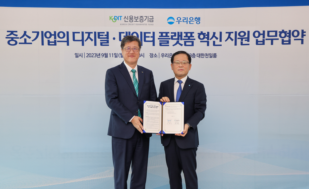 최원목 신용보증기금 이사장(왼쪽)과 조병규 우리은행장(오른쪽)이 11일 우리은행 본점에서 열린 '중소기업의 디지털·데이터 플랫폼 혁신 지원을 위한 업무협약'에 참석해 기념촬영을 하고 있다.