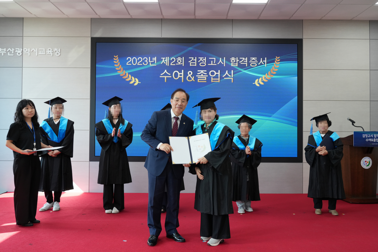 하윤수 부산시교육감(왼쪽)이 11일 오후 부산시교육청 별관에서 열린 '2023년 제2회 검정고시 합격자 졸업·수여식'에서 합격자에게 졸업증서를 수여하고 기념촬영을 하고 있다. [사진=부산교육청]