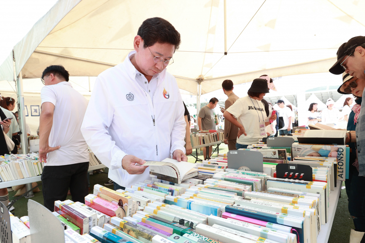 이상일 용인특례시장이 9일 열린 북페스티벌에서 도서관 제적도서를 1000원에 파는 '북 세일' 부스를 방문해 도서를 살펴보고 있다.[용인시 제공]