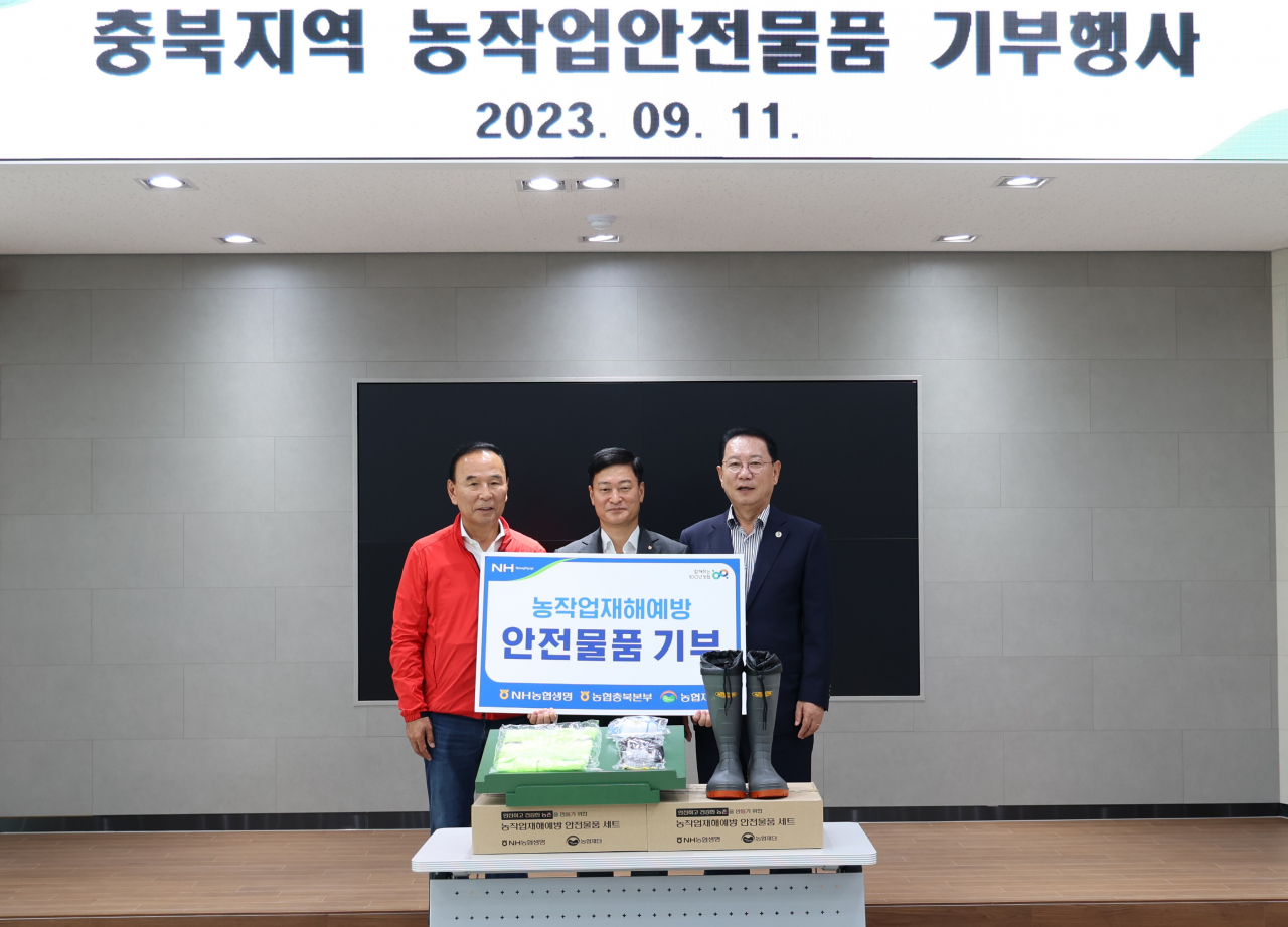NH농협생명이 11일 충북 괴산농협 경제종합지원센터 진행한 농작업안전물품 기부식에서 여운철(가운데) 농협생명 부사장, 박덕흠(왼쪽) 국회의원과 송인헌 괴산군수가 함께 기념촬영을 하고 있다. [NH농협생명 제공]