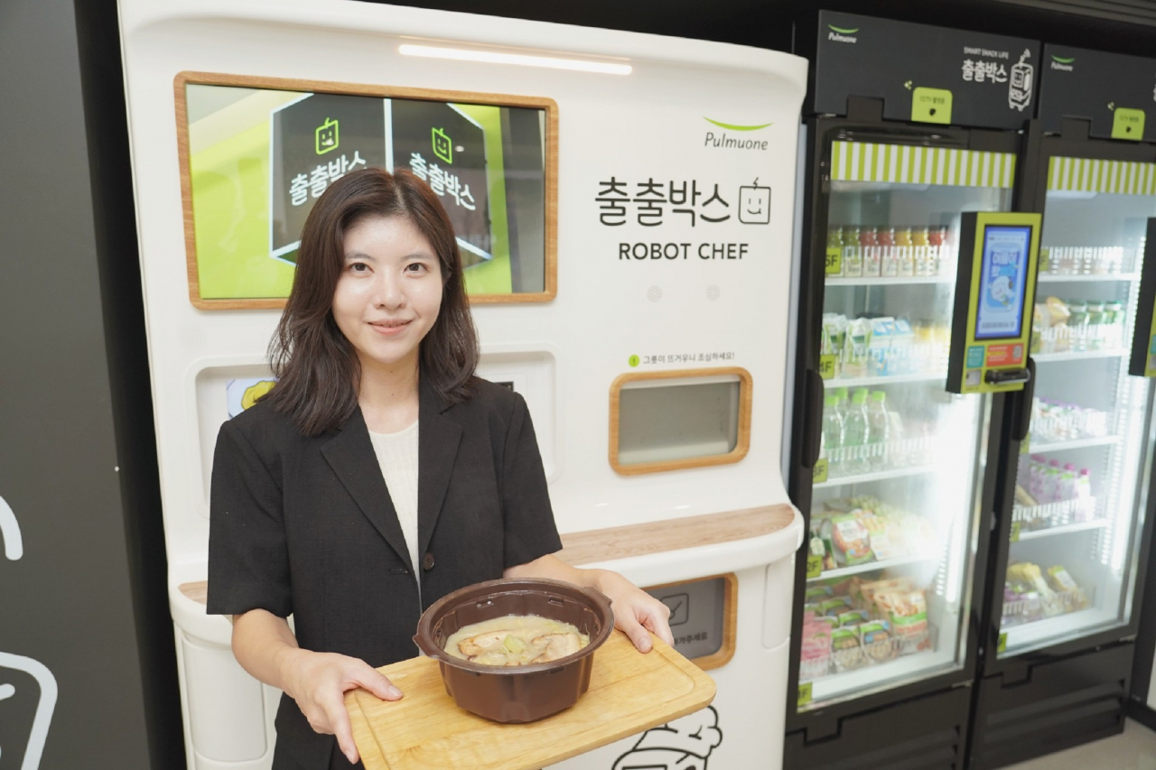 풀무원 직원이 스마트 무인 즉석조리 자판기 ‘출출박스 로봇셰프’로 구매한 메뉴를 선보이고 있다. [풀무원 제공\