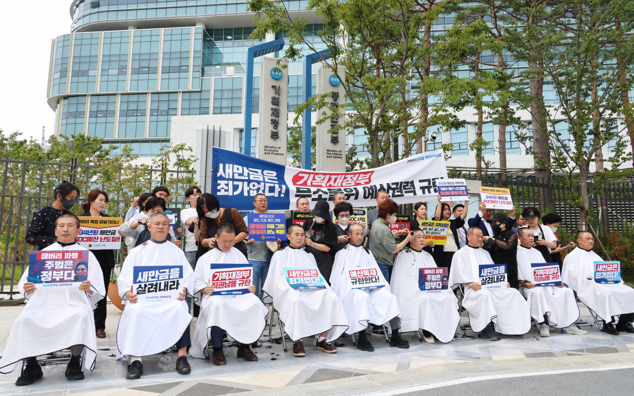 더불어민주당 한병도 의원(가운데)과 전북도의회 의원들이 12일 세종시 정부세종청사 기획재정부 앞에서 정부의 새만금 사회간접자본(SOC) 예산 삭감 방침에 맞서 삭발식을 하고 있다.[연합]