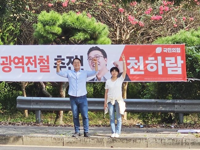 국민의힘 천하람 순천당협위원장과 같은당 이세은 순천시의원이 총선 공약 현수막을 배경으로 나란히 기념 촬영하고 있다. [천하람 측 제공]