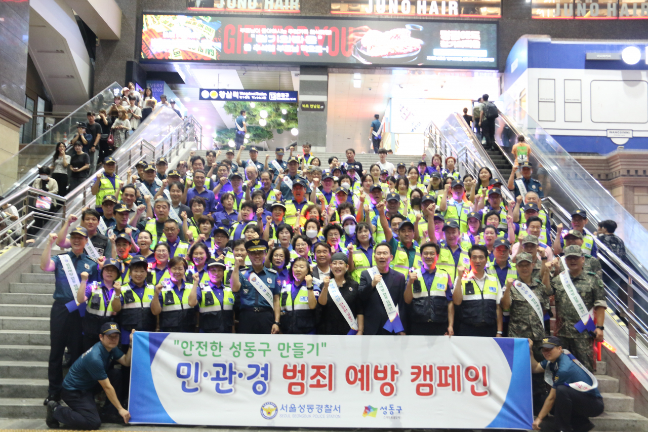 지난 12일 오후 8시께 서울 성동구 왕십리역의 계단에서 경찰과 협력단체(자율방범대, 청소년육성회, 청소년문화발전위원회, 개나리순찰대, 행당파출소 생활안전협의회) 약 165명이 민관경 범죄 예방 캠페인을 하고 있다. [서울 성동경찰서 제공]