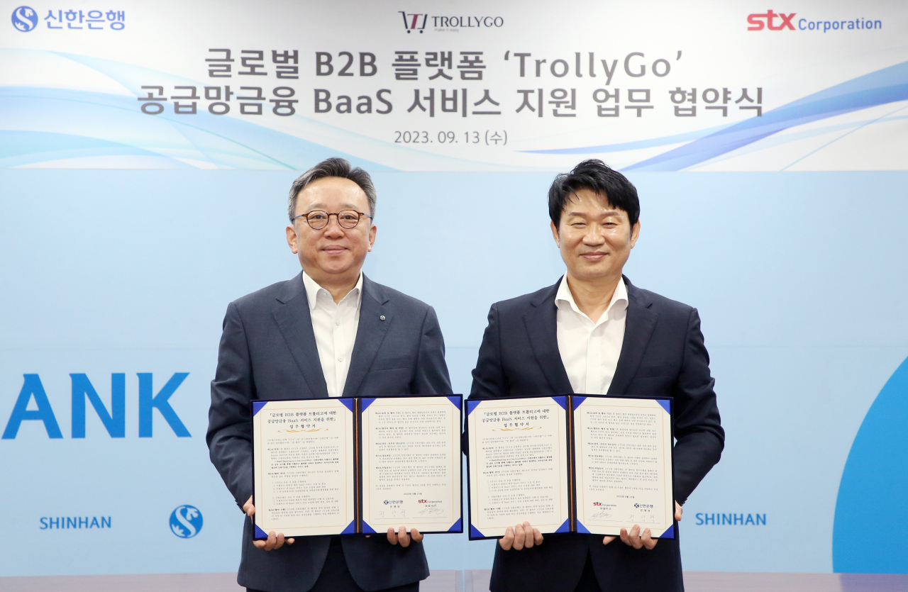 박상준(오른쪽) STX 대표이사와 정상혁 신한은행장이 지난 13일 서울 중구 신한은행 본점에서 글로벌 B2B 플랫폼 ‘트롤리고’ 공급망금융 BaaS 서비스 지원 업무협약(MOU)을 체결한 뒤 기념촬영을 하고 있다. [STX 제공]