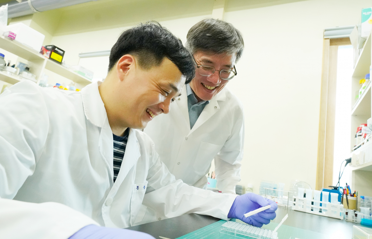 김민곤(오른쪽) 교수 연구팀이 감염된 시약 샘플을 키트에 떨어뜨려 인플루엔자 신속항원진단 키트를 테스트하고 있다.[GIST 제공]