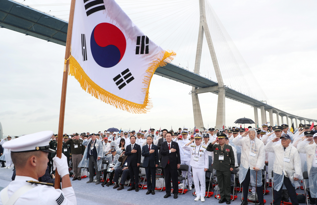 윤석열 대통령이 15일 인천항 수로 및 팔미도 근해 노적봉함에서 열린 제73주년 인천상륙작전 전승기념식에서 국기에 경례하고 있다. [연합]