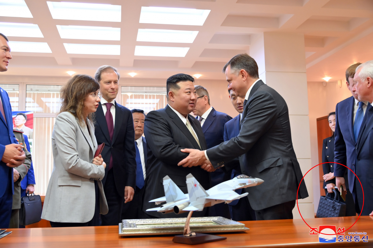 김정은 북한 국무위원장이 지난 15일 러시아 하바롭스크주 콤소몰스크나아무레시의 유리 가가린 전투기 공장을 방문했다고 조선중앙통신이 16일 보도했다. 김 위원장의 여동생 김여정 노동당 부부장이 러시아 비행기 공장 방문 당시 들었던 가방(붉은 원)이 프랑스 고가·사치품 브랜드 '크리스찬 디올(Christian Dior SE)'의 제품으로 추정된다. [국내에서만 사용가능. 재배포 금지. For Use Only in the Republic of Korea. No Redistribution] 연합뉴스