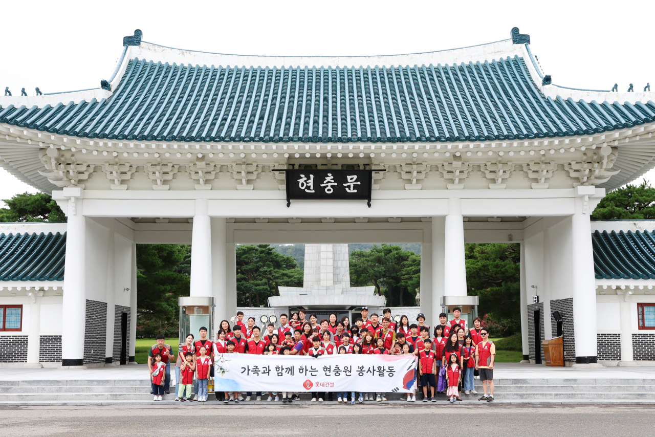 롯데건설 임직원과 가족들이 현충문 앞에서 봉사활동 후 기념 촬영을 하고 있다. [롯데건설 제공]