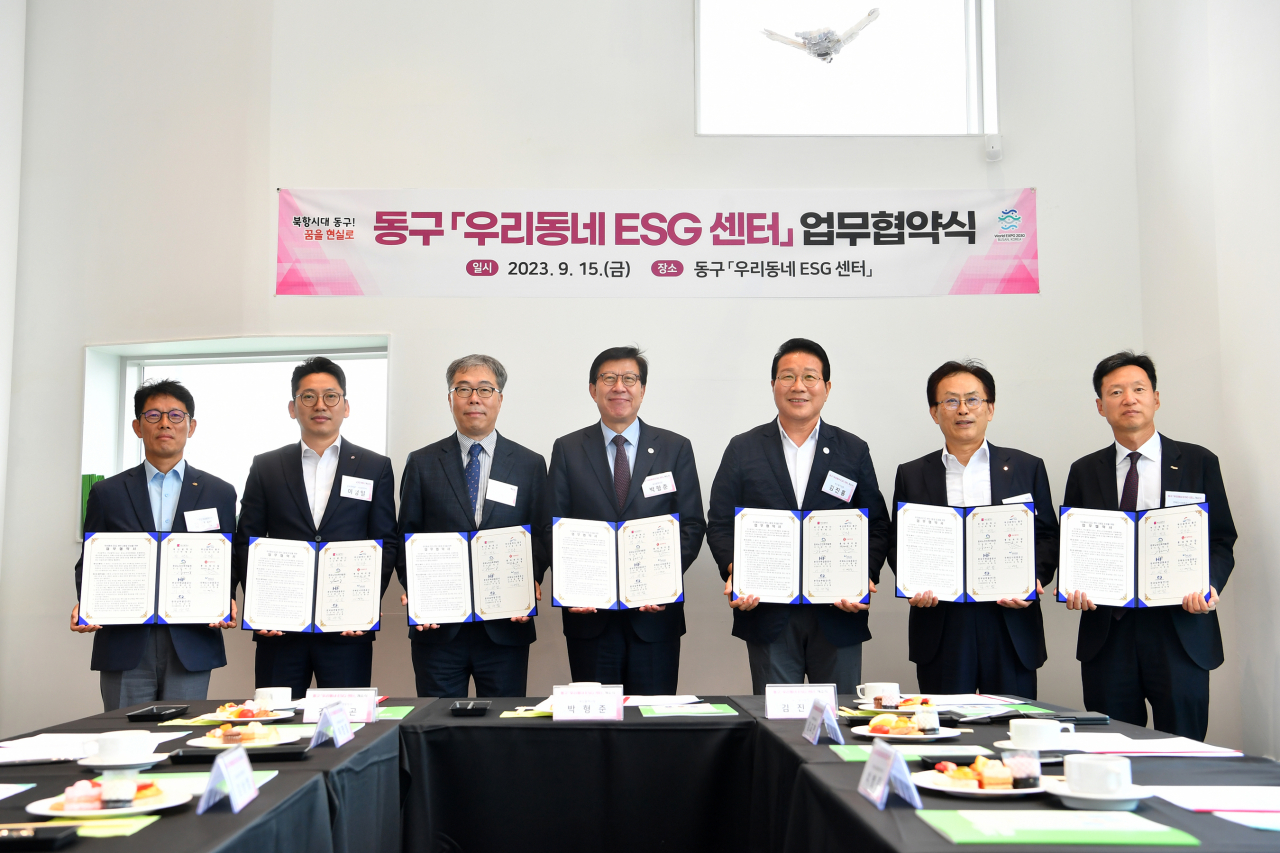지난 15일 부산 동구 ‘우리동네 ESG 센터’에서 진행된 업무협약식 후 참석자들이 기념 촬영을 하고 있다. 왼쪽부터 차례대로 김상범 한국남부발전 조달협력처장, 이정일 한국주택금융공사 상임이사, 김미곤 한국노인인력개발원장, 박형준 부산광역시장, 김진홍 부산광역시 동구청장, 김교현 롯데케미칼 부회장, 이병훈 주택도시보증공사(HUG) 부사장. [HUG 제공]