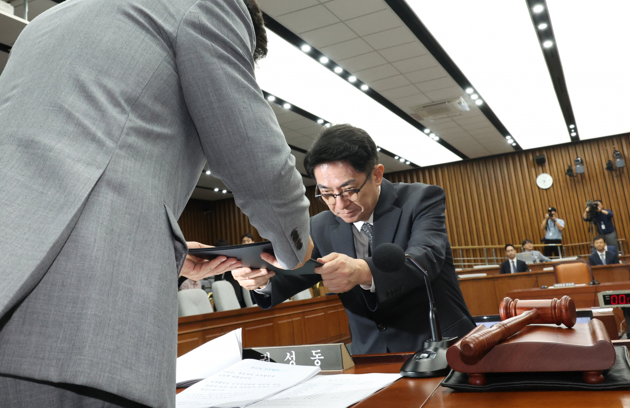 이균용 대법원장 후보자가 19일 국회에서 열린 인사청문회에서 선서를 한 뒤 선서문을 권성동 위원장에게 제출하고 있다. [연합]