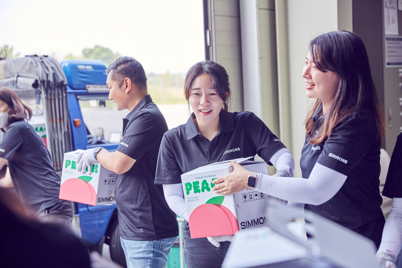 19일 경기 이천시에 위치한 시몬스 본사에서 임직원들이 지역 농산물인 복숭아를 포장 및 배송하고 있다. [시몬스 제공]