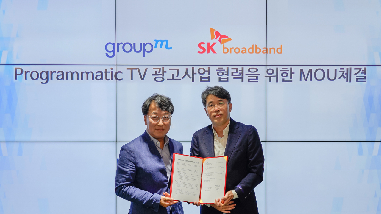 SK브로드밴드 본사에서 김혁(왼쪽) SK 브로드밴드 미디어 CO 담당과 권순재 그룹엠코리아 부사장이 상호협력 업무협약을 체결한 뒤 기념촬영을 하고 있다. [SK브로드밴드 제공]