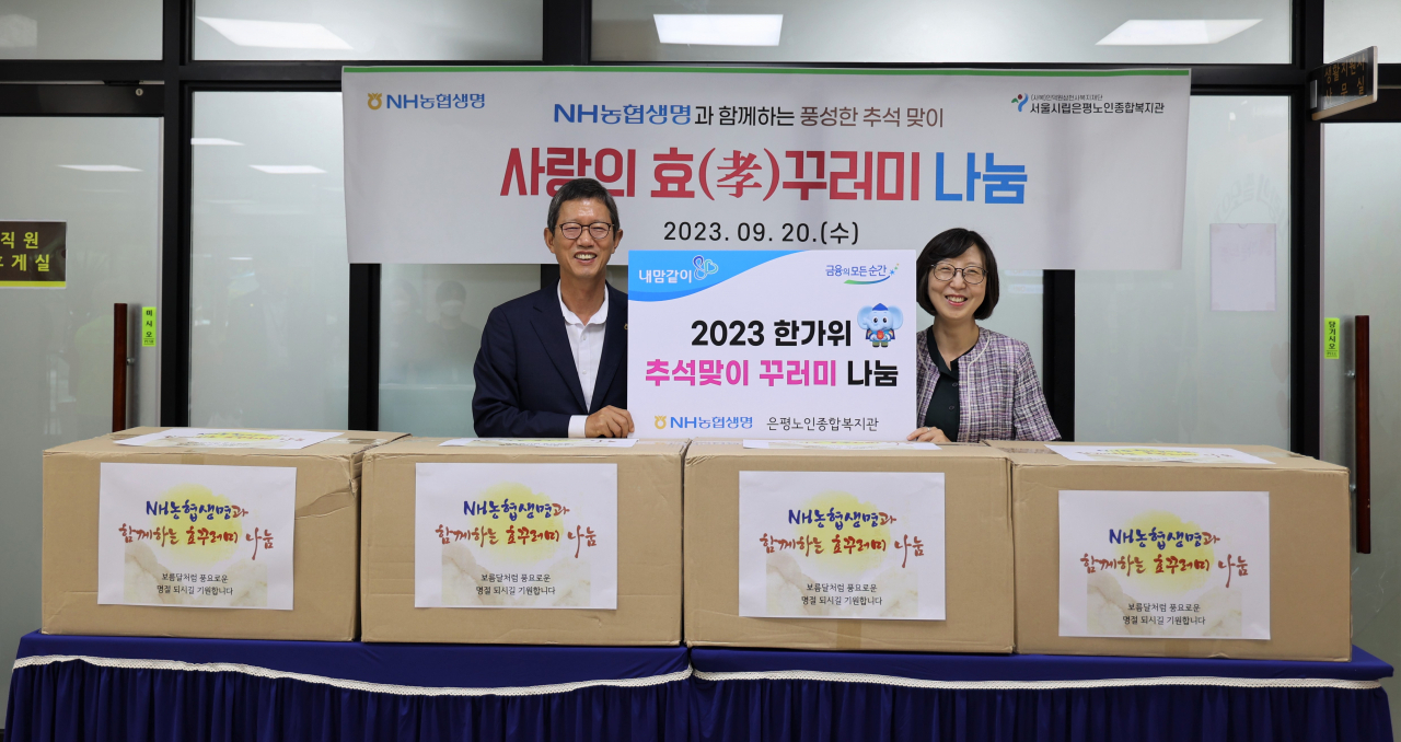 NH농협생명이 20일 진행한 추석 맞이 ‘사랑의 효 꾸러미 전달식’에서 윤해진(왼쪽) NH농협생명 대표이사와 이지은 은평노인종합복지관장이 기념촬영을 하고 있다. [NH농협생명 제공]