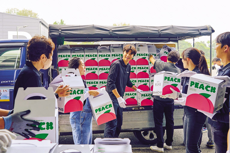 19일 경기 이천시에 위치한 시몬스 본사에서 임직원들이 지역 농산물인 복숭아를 포장 및 배송하고 있다. [시몬스 제공]