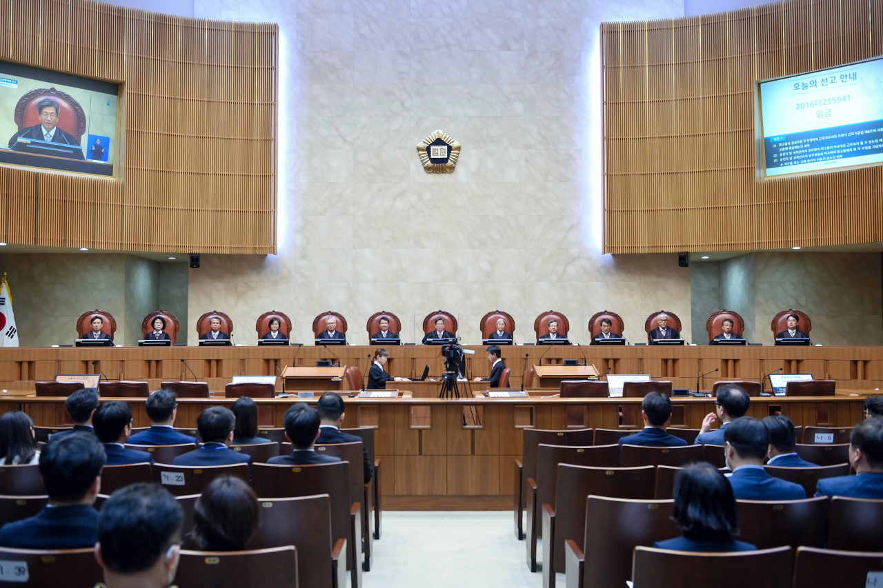 김명수 대법원장(가운데)과 12명의 대법관이 지난 21일 전원합의체 선고를 위해 자리에 앉아 있는 모습. [대법원 제공]