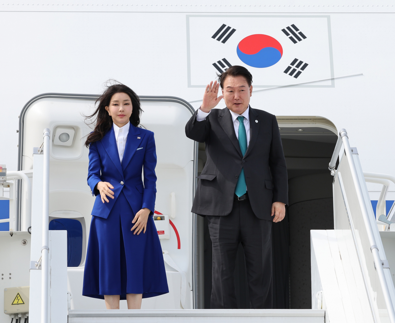 제78차 유엔총회 참석과 2030 부산세계박람회 유치를 위한 양자회담 등 일정을 소화한 윤석열 대통령과 부인 김건희 여사가 22일(현지시간) 미국 뉴욕 JFK공항에서 전용기인 공군 1호기에 올라 환송객들에게 손을 들어 인사하고 있다. [연합]