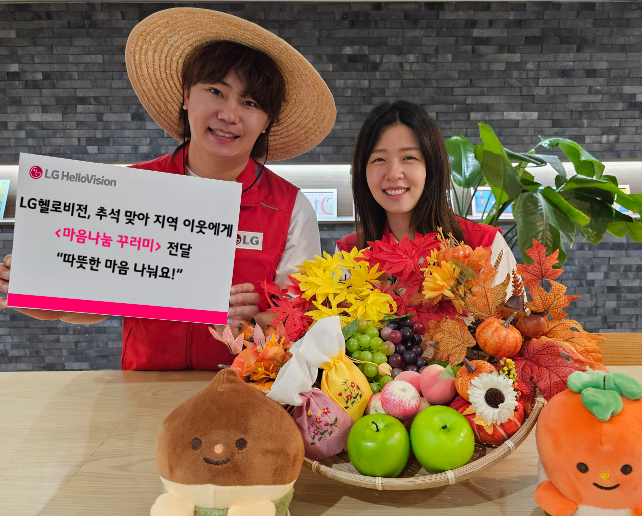 LG헬로비전 모델이 농수산물과 생필품이 담긴 ‘마음나눔 꾸러미’를 들고 있다. [LG헬로비전 제공]