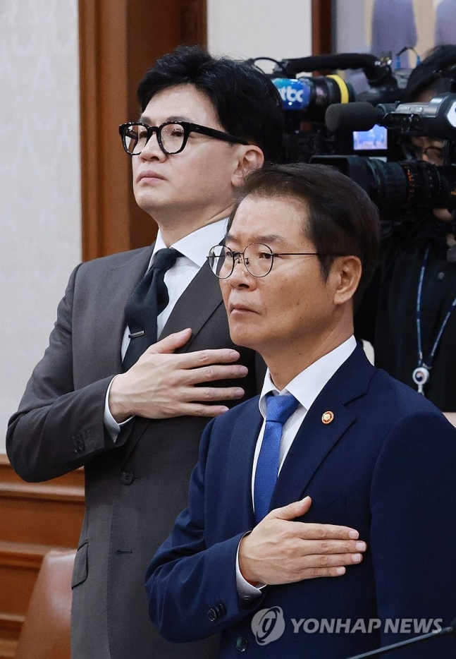 이정식 고용노동부 장관(오른쪽)과 한동훈 법무부 장관(왼쪽)이 19일 오전 서울 종로구 정부서울청사에서 열린 국무회의에 참석해 국기에 대한 경례를 하고 있다. [연합]
