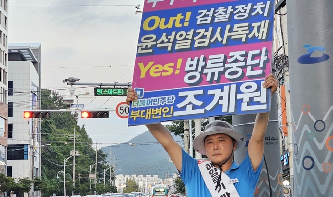조계원 민주당 부대변인이 여수 시내에서 검찰을 규탄하고 후쿠시마 오염수 방류를 규탄하는 피켓을 들고 있다.