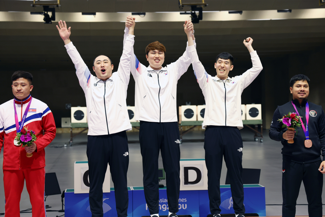 한국의 정유진 하광철 곽용빈이 사격 남자 10m 러닝타깃 단체전에서 금메달을 획득한 뒤 시상대에 올라 기뻐하고 있다. 연합뉴스