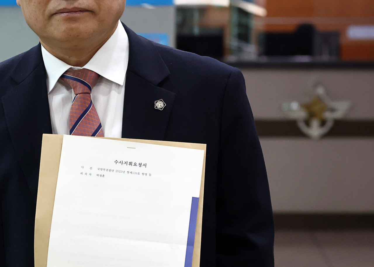 박정훈 전 해병대 수사단장(대령) 측 김정민 변호사가 25일 서울 국방부 종합민원인실에서 ‘검찰단장 직무배제 요청 수사지휘요청서’를 제출하기 앞서 관련 서류를 들어 보이고 있다. [연합]