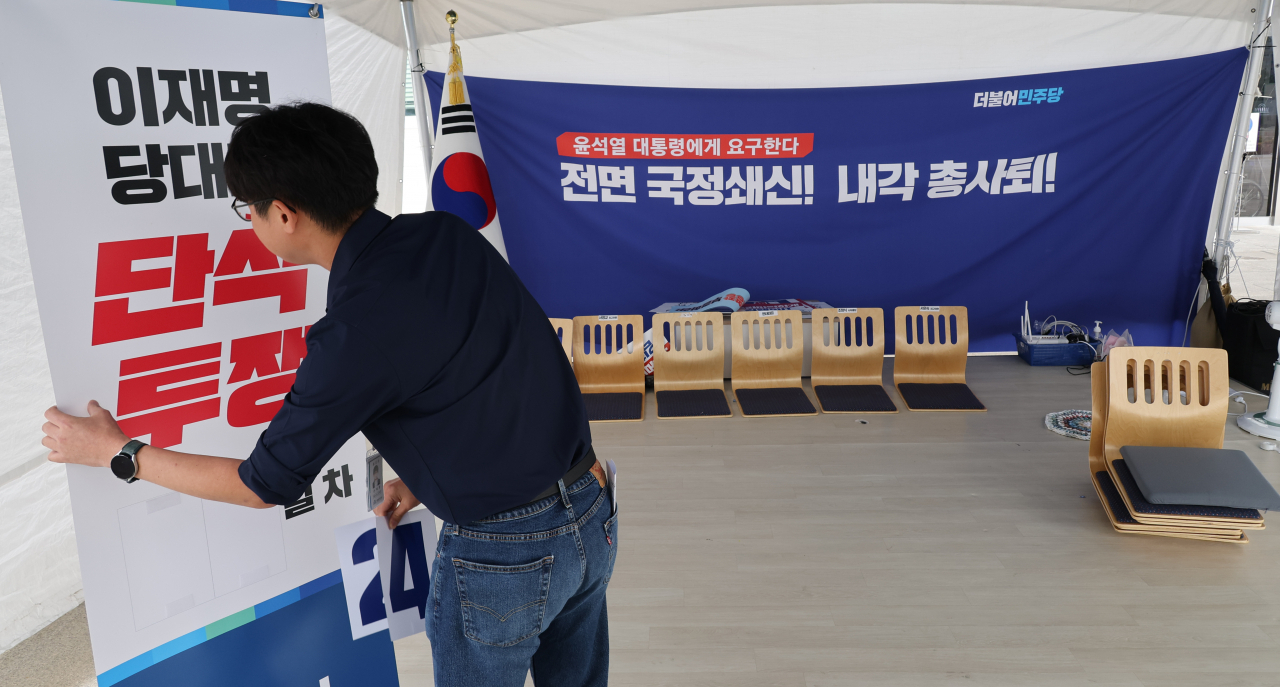 25일 더불어민주당 관계자가 국회 앞 이재명 대표 단식 농성장을 철거하고 있다. [연합]