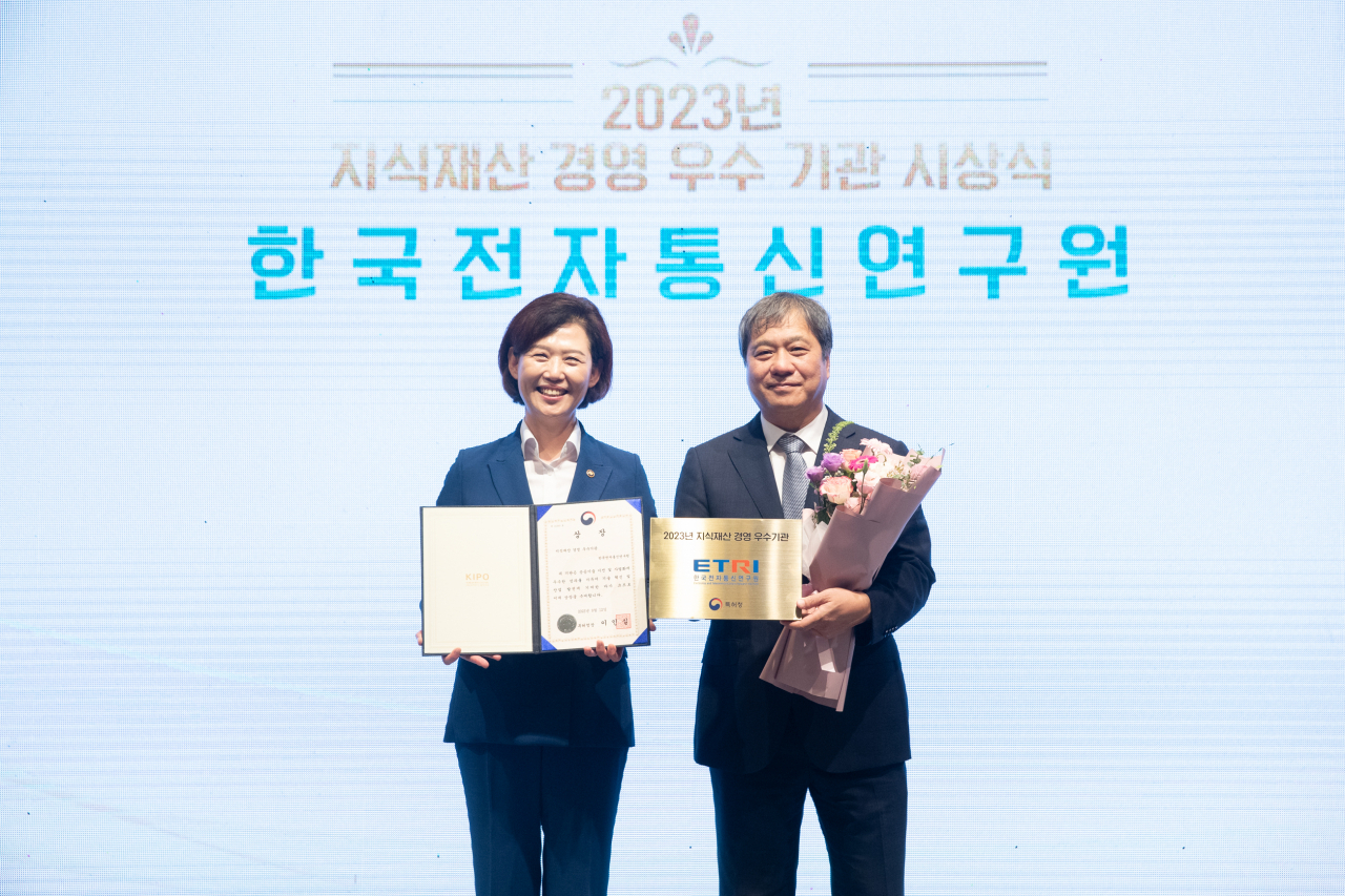 한국전자통신연구원(ETRI)가 2023년 지식재산 경영 우수기관으로 선정됐다. 왼쪽부터 이인실 특허청장, ETRI 강성원 부원장이 기념촬영을 하고 있다.[한국특허전략개발원 제공]