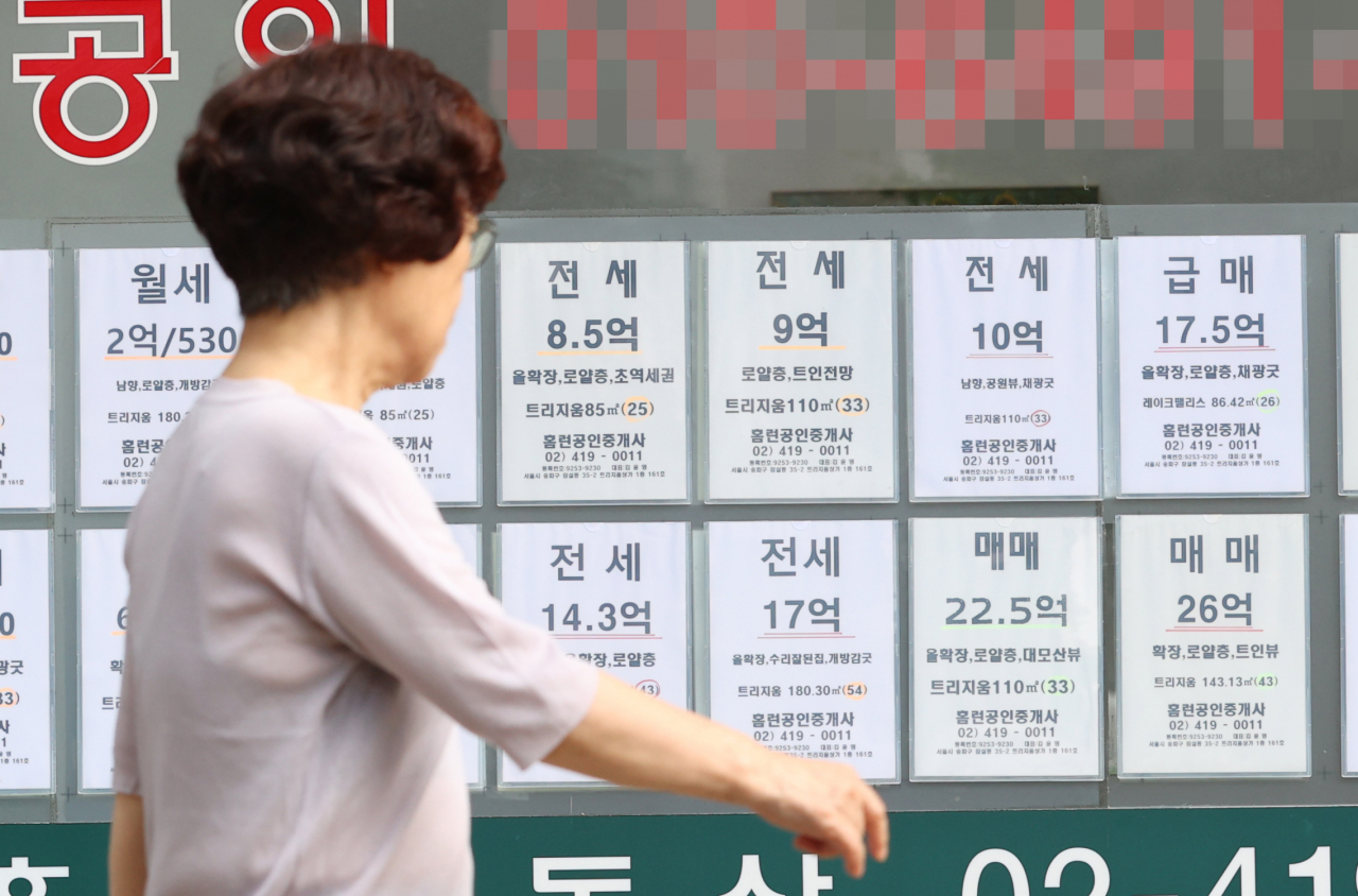 서울 한 부동산중개사무소 앞을 시민이 지나가고 있다.[연합]
