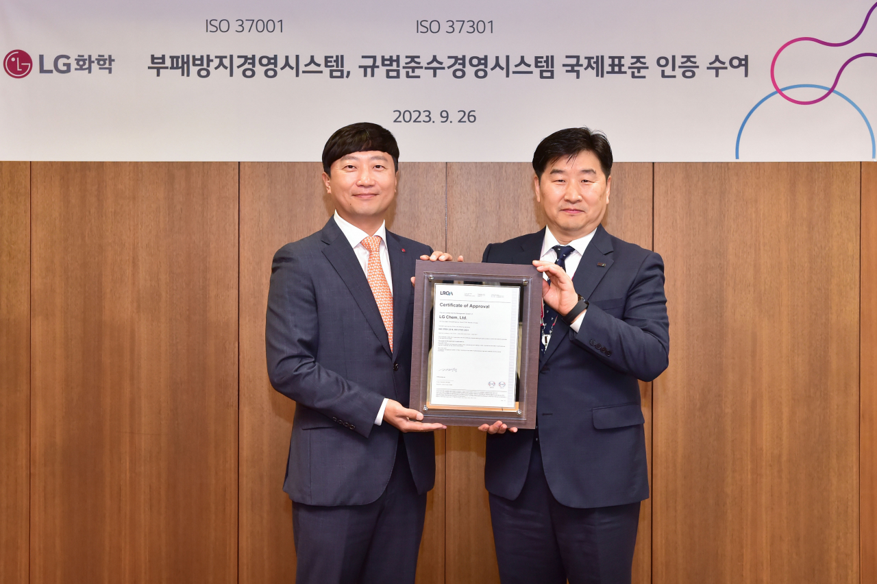 이규호(왼쪽) LG화학 법무실장이 26일 여의도 LG트윈타워에서 이일형 로이드인증원 대표이사로부터 컴플라이언스 및 부패방지 경영시스템 국제표준인증서를 받은 뒤 기념촬영을 하고 있다. [LG화학 제공]