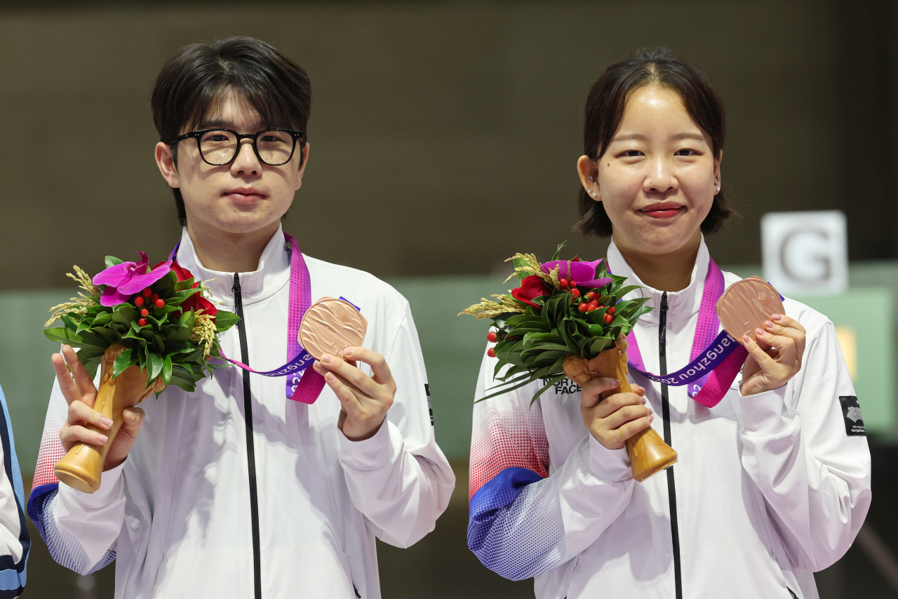26일 중국 항저우 푸양 인후 스포츠센터에서 열린 항저우 아시안게임 10m 공기소총 혼성 동메달 결정전에서 승리하며 동메달을 딴 박하준과 이은서가 시상대에 올라 기념 촬영하고 있다. [연합]