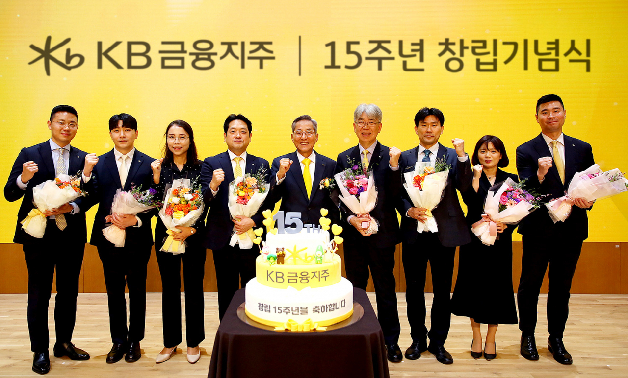 윤종규 KB금융그룹 회장(왼쪽 다섯 번째)이 27일 서울 영등포구 KB국민은행 본점에서 열린 KB금융지주 창립 15주년 기념식에서 장기근속 직원들과 기념 촬영하고 있다. 연합뉴스