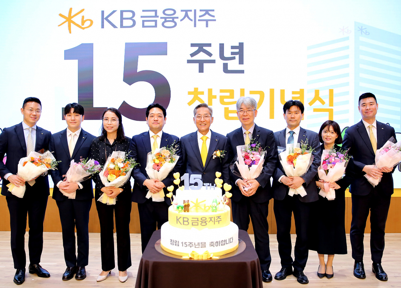 윤종규 KB금융그룹 회장(왼쪽 다섯 번째)이 27일 서울 영등포구 KB국민은행 본점에서 열린 KB금융지주 창립 15주년 기념식에서 장기근속 직원들과 기념 촬영하고 있다. 연합뉴스