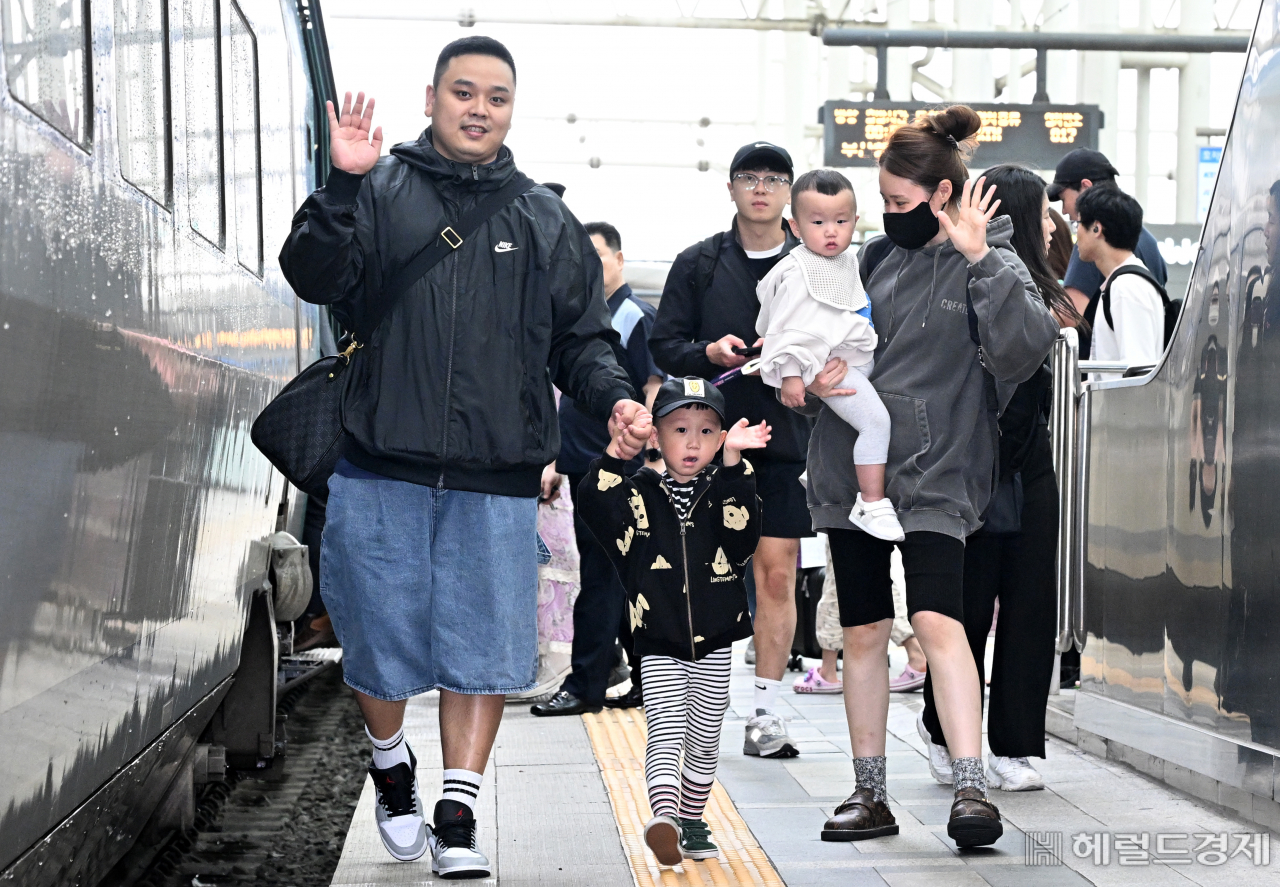 추석 연휴를 하루 앞둔 27일 서울 용산구 서울역 승강장에서 한 가족이 고향으로 향하는 기차에 오르고 있다. 임세준 기자