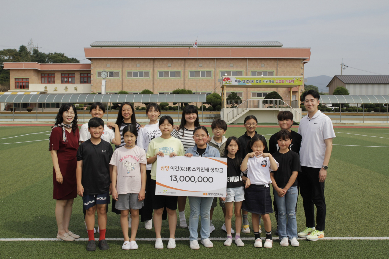 강원 평창군 대관령면 횡계초등학교 스키부 학생들과 교사가 삼양이건장학재단의 장학금을 받고 기념촬영을 하고 있다. [삼양식품 제공]