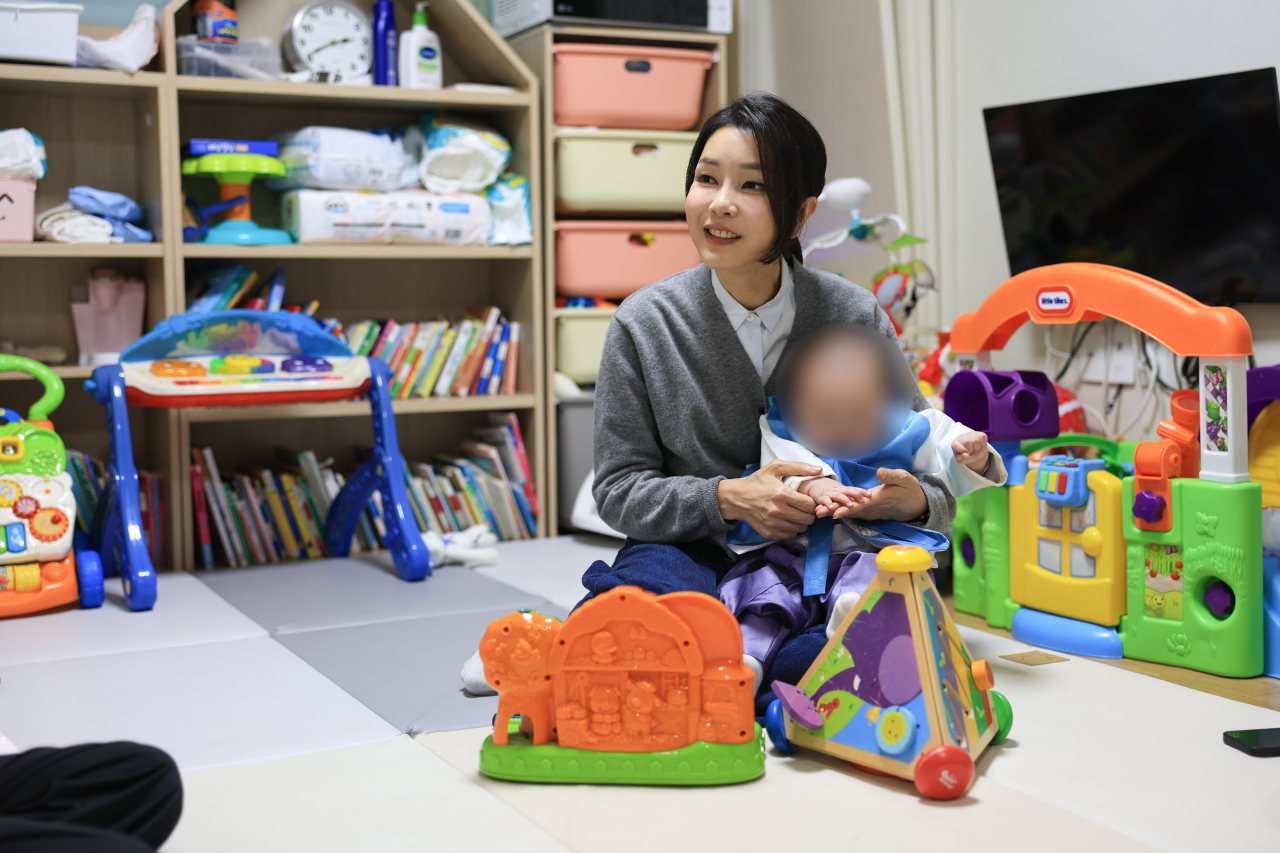 김건희 여사가 추석을 앞둔 27일 서울 송파구의 미혼모자가족 복지시설을 방문해 아이를 안아주며 미혼모와 대화하고 있다. [대통령실]