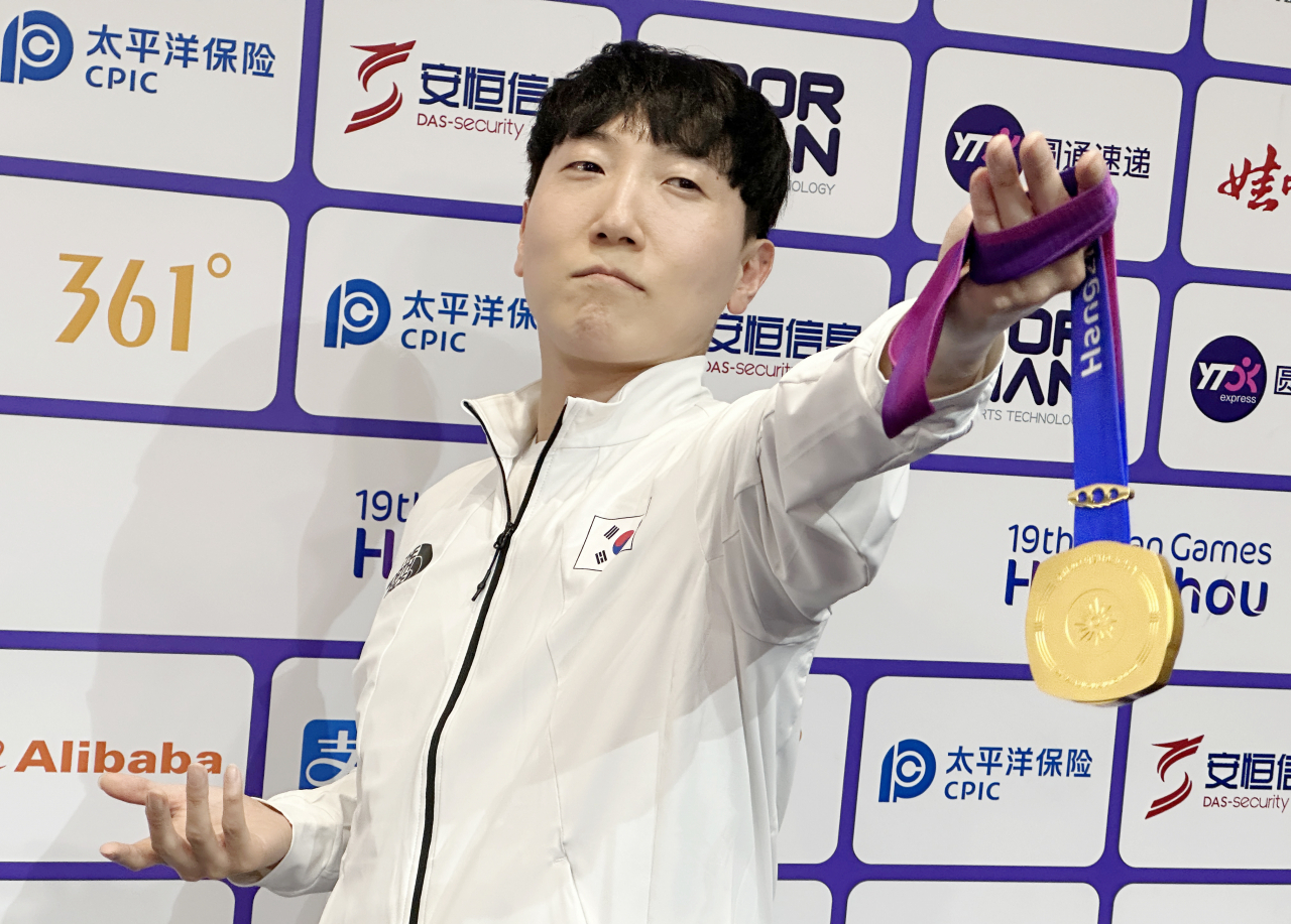 28일 중국 항저우 e스포츠센터에서 열린 2022 항저우 아시안게임(AG) 스트리트 파이터 V 결승전에서 대만의 샹여우린을 세트 점수 4-3으로 물리치고 금메달을 획득한 뒤 공동취재구역(믹스트존)에서 취재진을 향해 포즈를 취하고 있다. [연합]