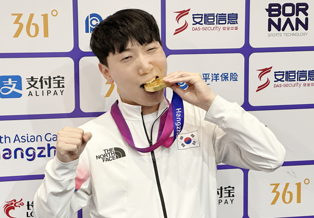 28일 중국 항저우 e스포츠센터에서 열린 2022 항저우 아시안게임(AG) 스트리트 파이터 V 결승전에서 대만의 샹여우린을 세트 점수 4-3으로 물리치고 금메달을 획득한 뒤 공동취재구역(믹스트존)에서 취재진을 향해 포즈를 취하고 있다. [연합]