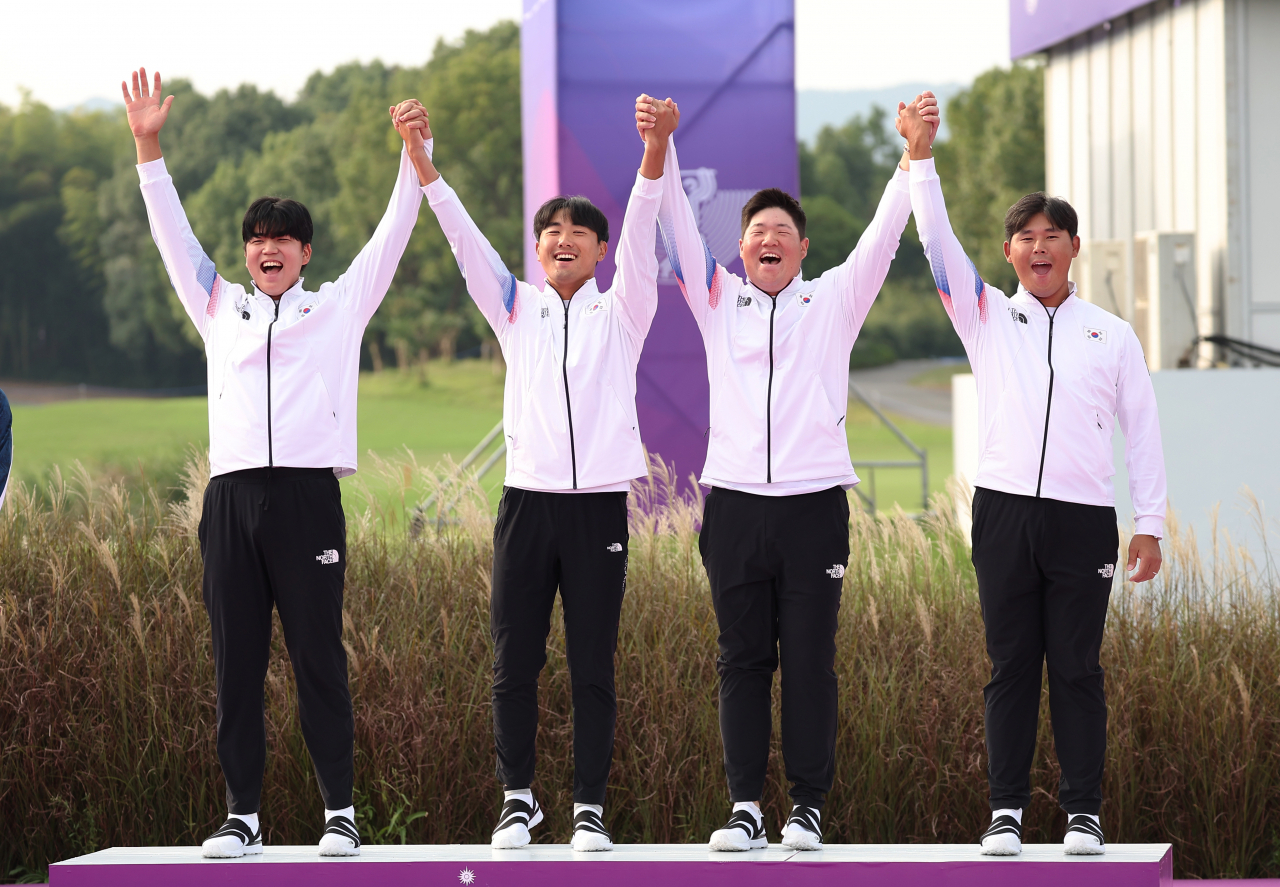 한국 골프 남자 대표팀 장유빈 조우영 임성재, 김시우(왼쪽부터)가 단체전 금메달을 따낸 뒤 시상대에서 환호하고 있다. 연합뉴스