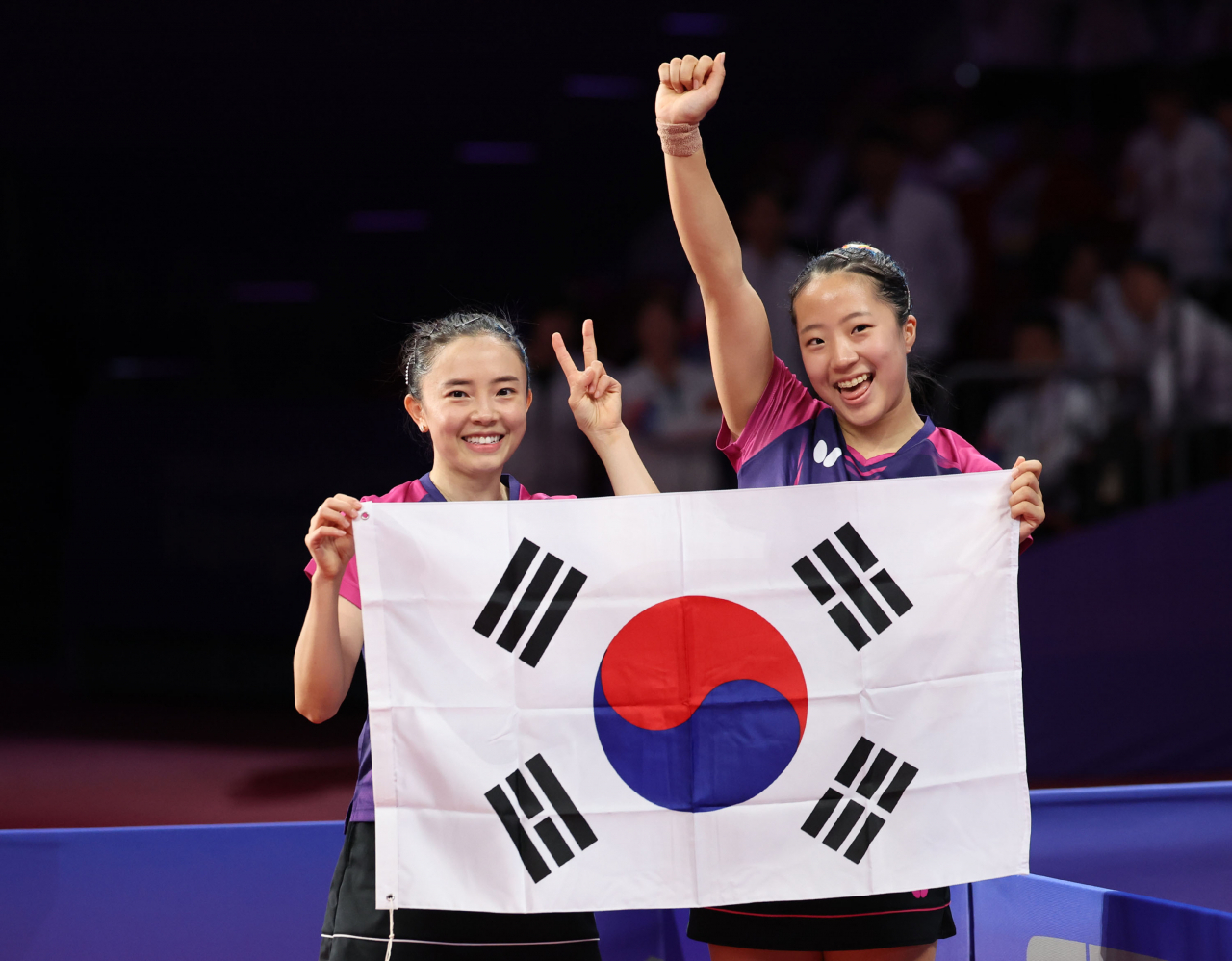 2일 중국 항저우 궁수 캐널 스포츠파크 체육관에서 열린 19회 항저우 아시안게임 탁구 여자 복식 결승전에서 한국 신유빈-전지희가 북한 차수영-박수경을 상대로 승리하며 금메달을 확정 지은 뒤 태극기를 들어보이고 있다. [연합]