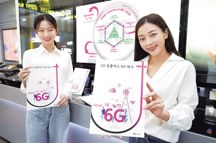 LG유플러스 모델이 성공적인 6G시대 진입을 위한 비전과 핵심 요구사항 등을 담은 ‘6G 백서’를 선보이고 있다. [LG유플러스 제공]