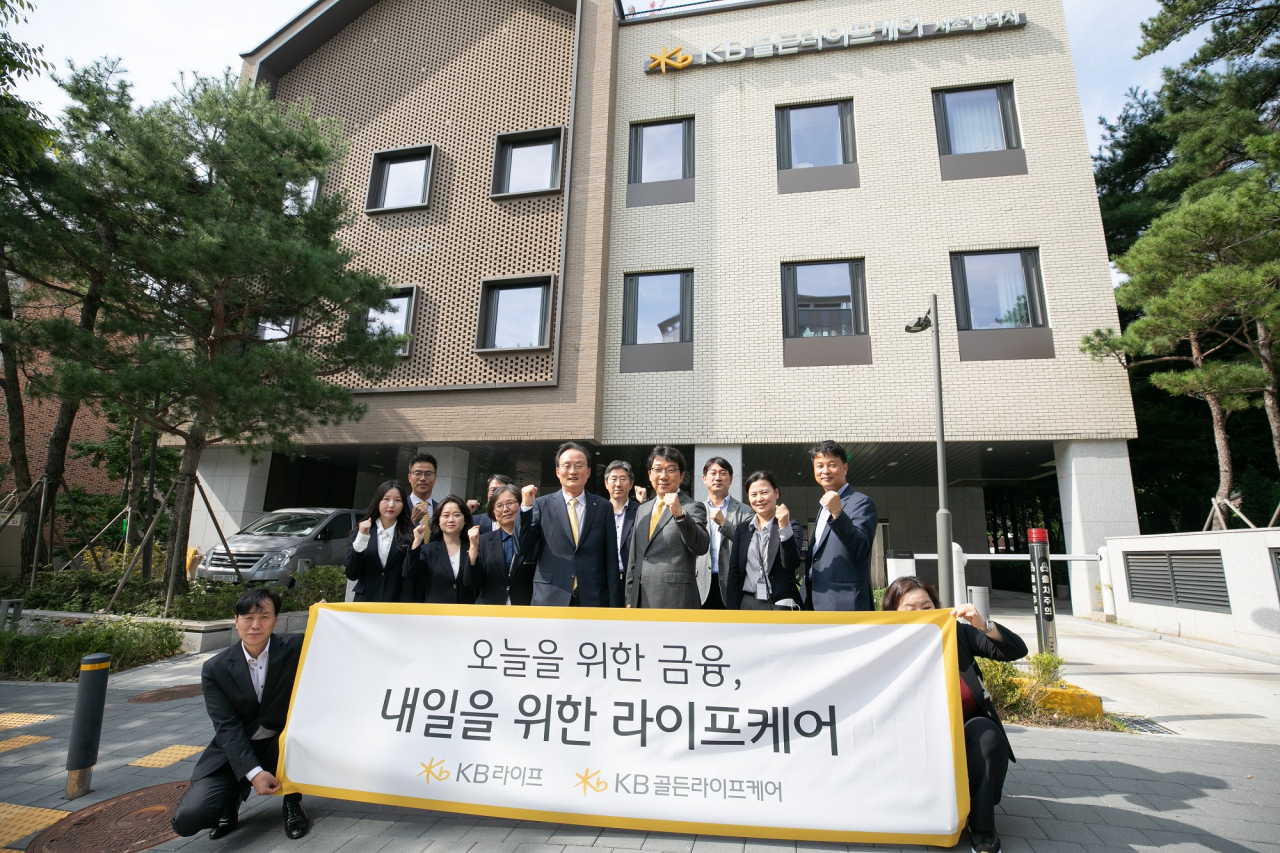 이환주(가운데 왼쪽) KB라이프생명 대표이사 사장이 4일 KB골든라이프케어의 자회사 편입을 기념해 KB골든라이프케어 서초빌리지를 방문하고 전영산(가운데 오른쪽) KB골든라이프케어 대표이사 및 임직원들과 함께 기념사진을 촬영하고 있다. [KB라이프생명 제공]