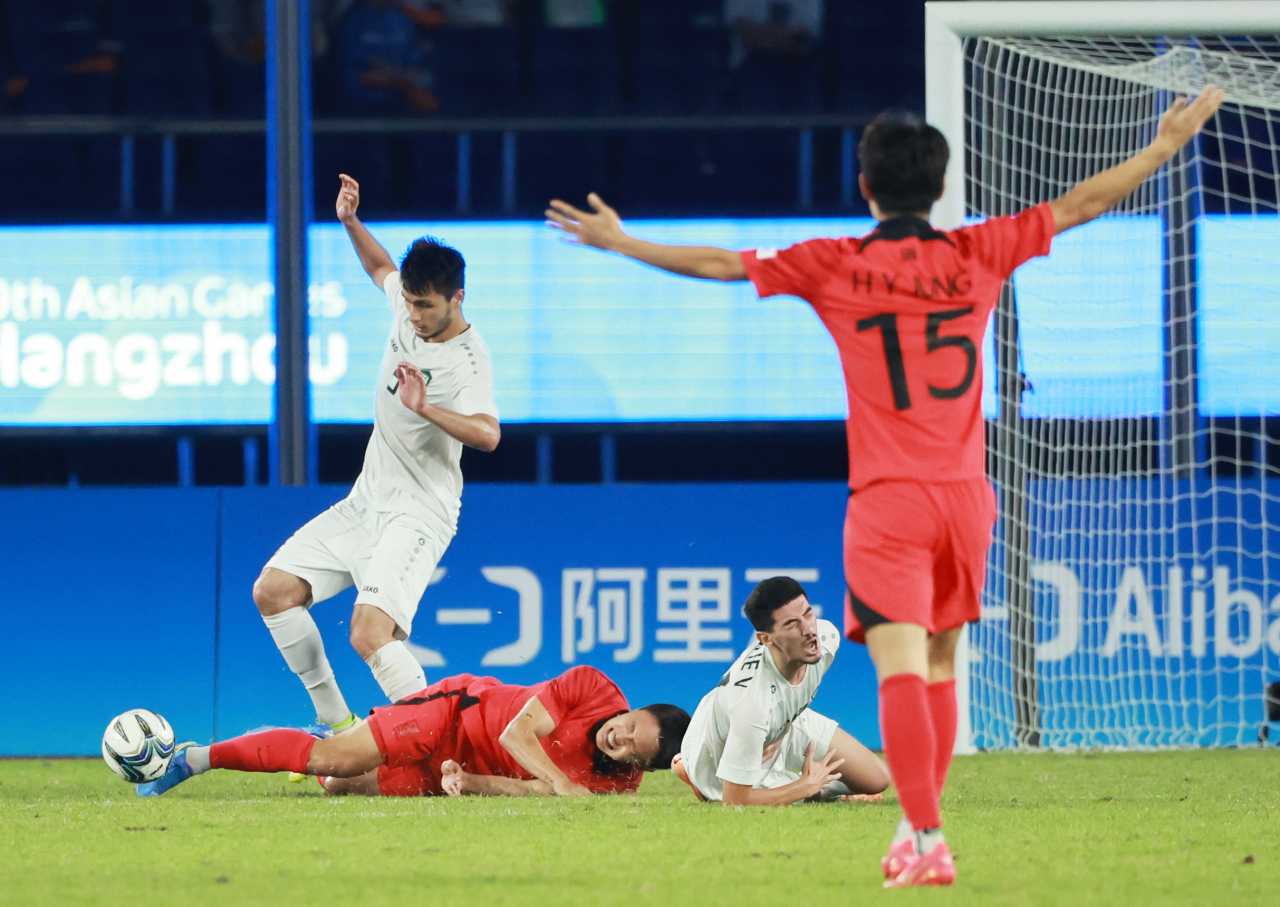 4일 중국 항저우 황룽 스포츠센터 스타디움에서 열린 2022 항저우 아시안게임 남자축구 4강전 대한민국과 우즈베키스탄의 경기. 조영욱이 파울을 당해 넘어져 고통을 호소하고 있다. [연합]